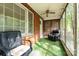 Enclosed porch with brick wall, sitting chairs, and ceiling fan at 1444 Harris St, Statesville, NC 28677