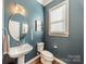 Chic powder room with a pedestal sink, mirror, and blue walls at 15133 Rocky Bluff Loop, Davidson, NC 28036