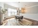 Sun-drenched dining room features a modern round table and chairs, complemented by stylish decor and natural light at 15133 Rocky Bluff Loop, Davidson, NC 28036
