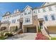 Exterior view of townhomes featuring brick facade, two-car garages and well maintained landscaping at 15133 Rocky Bluff Loop, Davidson, NC 28036