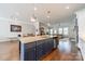 Bright open kitchen with island and seating, stainless steel appliances, and spacious living area at 15133 Rocky Bluff Loop, Davidson, NC 28036