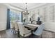 Elegant dining room with modern chandelier, stylish wallpaper, and large window with blue curtains at 167 Glenn Dr, Mooresville, NC 28115