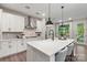 Contemporary kitchen with white cabinets, stainless steel hood, waterfall island, and pendant lighting at 167 Glenn Dr, Mooresville, NC 28115