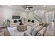 Comfortable living room with fireplace, white sofas, stylish decor, and staircase with metal spindles at 167 Glenn Dr, Mooresville, NC 28115