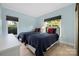 Comfortable bedroom showcasing two twin beds with blue bedding and natural light from the windows at 18700 Nautical Dr # 101, Cornelius, NC 28031