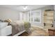 This bedroom features light-colored walls, hardwood floors, built-in bookcase, and a window with bright natural light at 207 Blythe Mill Rd, Waxhaw, NC 28173