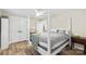 Cozy bedroom with wood floors, a four poster bed with a grey and white striped comforter, and ensuite closet at 207 Blythe Mill Rd, Waxhaw, NC 28173