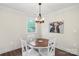 Cozy dining area featuring a unique wooden table, white chairs, and a modern chandelier fixture at 207 Blythe Mill Rd, Waxhaw, NC 28173