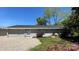 Charming single-story home featuring a brick facade, gravel driveway, and lush landscaping at 207 Blythe Mill Rd, Waxhaw, NC 28173