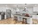 Modern kitchen with stainless steel refrigerator, white cabinets, black countertops, an island, and pendant lighting at 207 Blythe Mill Rd, Waxhaw, NC 28173