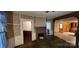 An inviting living room featuring a brick fireplace and views into the kitchen at 224 Charlotte St, York, SC 29745