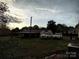 Backyard view showcasing parking area and home, set against a sky filled with beautiful clouds at dusk at 2508 S Main St # 68, Concord, NC 28027