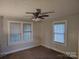Spacious bedroom with neutral walls and carpet, featuring a ceiling fan and natural light from two windows at 2508 S Main St # 68, Concord, NC 28027