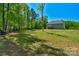 Expansive backyard with lush lawn, mature trees, and inviting covered porch on a beautiful two-story home at 3011 Waxhaw Crossing Dr, Waxhaw, NC 28173