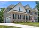 Stylish two-story home featuring a brick facade, grey siding, an attached garage, and well-maintained landscaping at 3011 Waxhaw Crossing Dr, Waxhaw, NC 28173