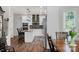 Open kitchen with white cabinets, stainless steel appliances and granite counters is adjacent to dining area at 3011 Waxhaw Crossing Dr, Waxhaw, NC 28173