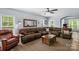 Spacious living room with a large brown sectional sofa, a wooden coffee table, and a decorative mirror at 3011 Waxhaw Crossing Dr, Waxhaw, NC 28173