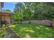 A well-maintained backyard with a wooden fence, green lawn, and covered back porch at 3228 E Ford Rd, Charlotte, NC 28205