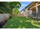 A spacious, green, fenced backyard featuring landscaping near the house, and surrounded by mature trees offering shade at 3228 E Ford Rd, Charlotte, NC 28205