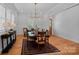 Bright dining room with hardwood floors, wainscoting, and a modern chandelier over a large dining table at 3228 E Ford Rd, Charlotte, NC 28205