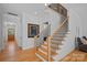 Bright foyer with hardwood floors, staircase with black iron railing, and view to wood door in this lovely home at 3228 E Ford Rd, Charlotte, NC 28205