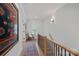 Bright hallway with hardwood floors, stylish rug, and staircase with modern black metal and wood railing at 3228 E Ford Rd, Charlotte, NC 28205