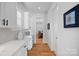 Hallway featuring white cabinets with white countertop, hardwood floors, and views into the dining room at 3228 E Ford Rd, Charlotte, NC 28205