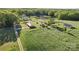 Expansive estate with multiple buildings, pond, and surrounding green fields and forests at 36984 B&C Carter Rd, New London, NC 28127