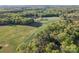 Breathtaking aerial view of a sprawling property featuring lush greenery, a serene pond, and multiple buildings at 36984 B&C Carter Rd, New London, NC 28127