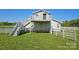 Barn with a white exterior, fenced-in yard, exterior stairs, and balcony at 36984 B&C Carter Rd, New London, NC 28127