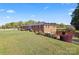 Sprawling two-story brick home with a metal roof, manicured lawn, and mature landscaping at 36984 B&C Carter Rd, New London, NC 28127