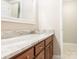 A vanity with marble countertops, framed mirror and a door leading to a bathroom at 3815 Glen Haven Sw Dr, Concord, NC 28027