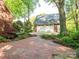 A brick driveway leads to a detached garage with lovely landscaping and mature trees at 3815 Glen Haven Sw Dr, Concord, NC 28027