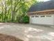 Detached brick garage with white doors and ample parking space on the large concrete driveway at 3815 Glen Haven Sw Dr, Concord, NC 28027