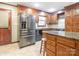 Kitchen with stainless steel refrigerator, granite counters, and wood cabinets and a convenient island at 3815 Glen Haven Sw Dr, Concord, NC 28027
