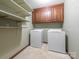 Functional laundry room with overhead cabinets and shelving at 3815 Glen Haven Sw Dr, Concord, NC 28027