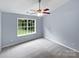 Cozy bedroom featuring a large window, ceiling fan, and neutral carpet at 526 Pennyfields Ln, Clover, SC 29710
