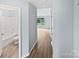 Hallway leading to a bathroom and living room with consistent wood-look flooring throughout at 526 Pennyfields Ln, Clover, SC 29710