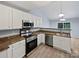 Well-lit kitchen with stainless steel appliances, white cabinets, and wood-style flooring at 526 Pennyfields Ln, Clover, SC 29710