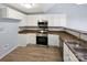 Kitchen featuring white cabinets, stainless steel appliances, and wood-look floors at 526 Pennyfields Ln, Clover, SC 29710