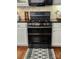 Modern black stainless steel range complementing the white cabinets and granite counters at 5505 Weavers Row, Gastonia, NC 28056