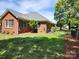 Spacious backyard featuring a well-maintained lawn, with a view of the home's brick exterior at 5505 Weavers Row, Gastonia, NC 28056