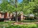 Home's exterior with a well-manicured lawn, mature trees, and a black metal fence at 5505 Weavers Row, Gastonia, NC 28056