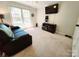Carpeted bedroom featuring a black sofa, TV, and a bright window, perfect for relaxation at 5505 Weavers Row, Gastonia, NC 28056