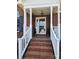 Welcoming front porch with brick steps and classic white railings, leading to an inviting entrance and charming details at 5505 Weavers Row, Gastonia, NC 28056