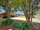 Charming brick home with lush landscaping and mature trees lining the driveway at 5505 Weavers Row, Gastonia, NC 28056