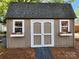 Exterior view of shed with flower boxes under each window and brown double doors at 5505 Weavers Row, Gastonia, NC 28056