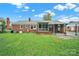 Backyard view with a sunroom, covered porch, and brick exterior at 7410 Middlebury Pl, Charlotte, NC 28212