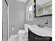 Bathroom with a vanity, toilet, window, shower with glass door and grey paint at 7410 Middlebury Pl, Charlotte, NC 28212
