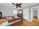 Bedroom with wood floor, neutral walls, closet and ceiling fan with decorative trim above the bed at 7410 Middlebury Pl, Charlotte, NC 28212